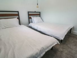 A bedroom with two beds and a light fixture at The Lookout in Redruth