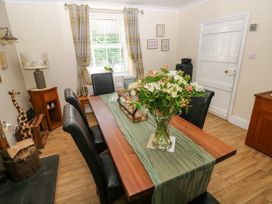 A dining room with a wooden table and chairs at St.Twynells Farm in Pembroke