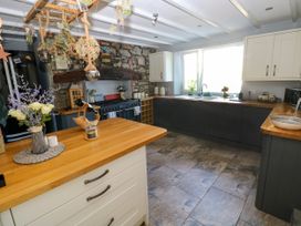 A kitchen with cabinets and a stove at St.Twynells Farm in Pembroke