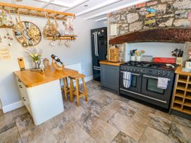 A kitchen with a table and stools at St.Twynells Farm in Pembroke