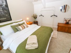 A bedroom with a bed and a clothes rack at St.Twynells Farm in Pembroke
