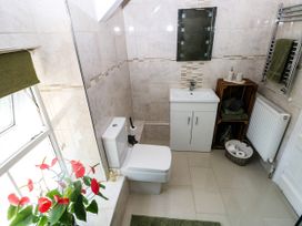 A bathroom featuring a toilet, sink, and towel radiator at St.Twynells Farm, Pembroke