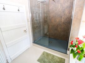 A bathroom with a shower and a door at St.Twynells Farm in Pembroke