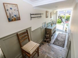 A hallway with a chair and storage cabinet at St.Twynells Farm in Pembroke