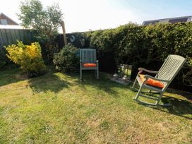A garden with rocking chairs and bushes at St.Twynells Farm in Pembroke