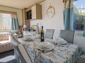 A dining room with a table set for dinner at Beech Walk 3 Sandy Bay, Exmouth