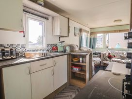 A kitchen with cabinets and appliances at Beech Walk 3 Sandy Bay Exmouth