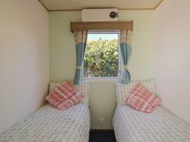A bedroom with two single beds and a window at Beech Walk 3 Sandy Bay, Exmouth