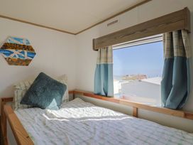 A bedroom with a bed and window at Beech Walk 3 Sandy Bay, Exmouth