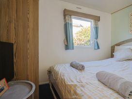 A bedroom with a bed and television at Beech Walk 3 Sandy Bay, Exmouth