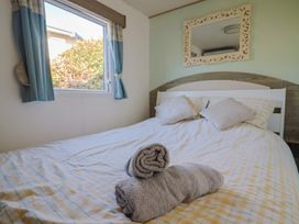 A bedroom with a bed and window at Beech Walk 3 Sandy Bay, Exmouth