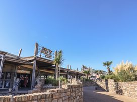 A cafe sign with palm trees and stone wall at South Beach Cafe in Sandy Bay, Exmouth