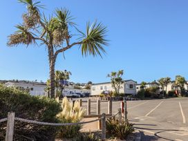 An outdoor area with caravans and palm trees at Beech Walk 3 Sandy Bay Exmouth