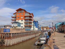A marina with boats and colorful buildings at Beech Walk 3 Sandy Bay, Exmouth