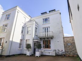 An outdoor view of a building with a balcony and trees at 2 St. Michaels House Lyme Regis