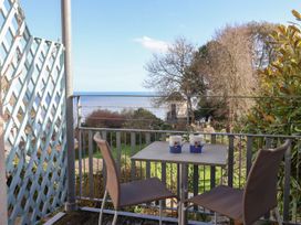 A balcony with a table and chairs overlooking the sea at 2 St. Michaels House Lyme Regis