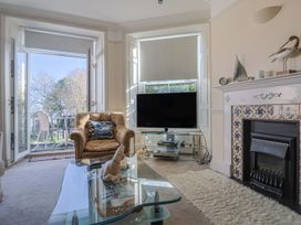 A living room with a sofa and a television at 2 St. Michaels House in Lyme Regis