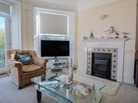 A living room with a sofa, television, and coffee table at 2 St. Michaels House in Lyme Regis