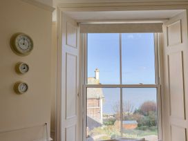 A room with clocks on the wall and a view of the ocean at 2 St. Michaels House in Lyme Regis