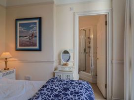 A bedroom with a bed, bedside table, and shower at 2 St. Michaels House in Lyme Regis