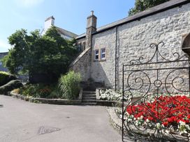An outdoor view with a stone building and flower garden at 2 St. Michaels House Lyme Regis