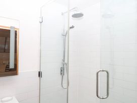 A shower with glass panels and a shower head at The Hayloft at Manaton