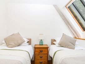 A bedroom with two beds and a bedside table at The Hayloft at Manaton