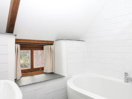 A bathroom with a bathtub and a window at The Hayloft at Manaton