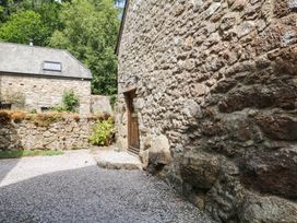 An outdoor area with stone walls and a door at The Hayloft at Manaton