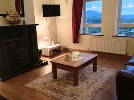 A living room with a fireplace and television at Sliabh League Mountain Lodge TEILEANN near Kilcar, County Donegal