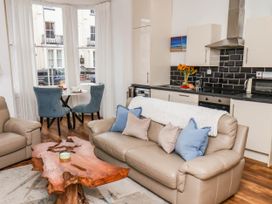 A living room with a dining table and kitchen area at Flat 1 in Whitby