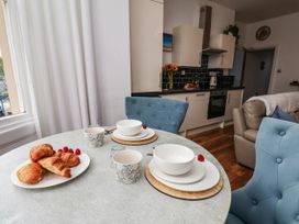 A dining room with pastries and coffee cups at Flat 1 in Whitby