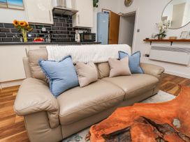 A living room with a sofa and kitchen area at Flat 1 in Whitby