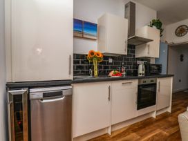 A kitchen with appliances and flowers at Flat 1 in Whitby