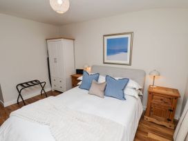 A bedroom with a bed and nightstand at Flat 1 in Whitby