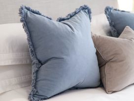 A blue and gray pillow on a bed at Flat 1 in Whitby
