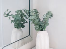 A plant in a vase reflected in a mirror at Flat 1 in Whitby
