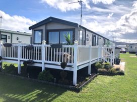 A caravan with a deck and planters at Sandy beach retreat in Prestatyn
