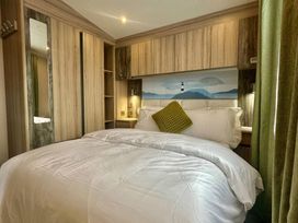 A bedroom with a bed and wardrobes at 101 Bay View in Ayr