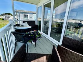 A balcony with a table and chairs at Craig Tara Holiday Park 101 Bay View, Ayr