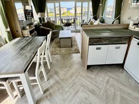 A living room with a dining table and chairs at Craig Tara Holiday Park 101 Bay View in Ayr