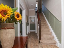 A hallway with stairs and flowers at Lansdowne Grange in Bridlington