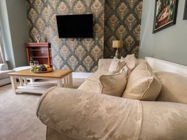 A living room with a television and coffee table at Lansdowne Grange in Bridlington