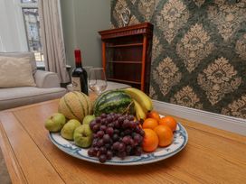 A living room with a fruit bowl on a table at Lansdowne Grange in Bridlington