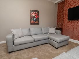 A living room with a gray sofa and a painting at Lansdowne Grange in Bridlington