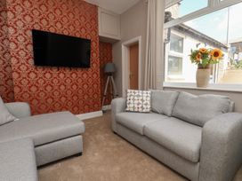 A living room with a sofa and a television at Lansdowne Grange in Bridlington
