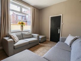 A living room with sofas and a vase of flowers at Lansdowne Grange in Bridlington