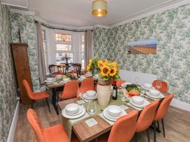 A dining room with a large table set for a meal at Lansdowne Grange in Bridlington