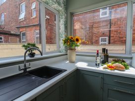 A kitchen with a sink and flowers on a counter at Lansdowne Grange in Bridlington