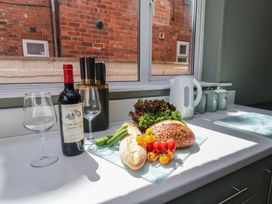 A kitchen countertop with wine, glasses, vegetables, and a kettle at Lansdowne Grange in Bridlington